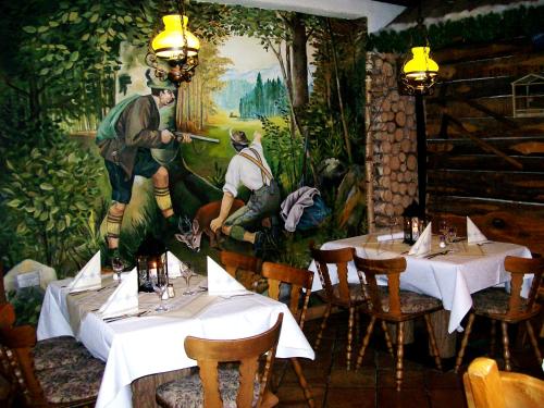 巴特拉珀瑙Wirtshaus zum Wilddieb的餐厅设有两张桌子,墙上挂着一幅画