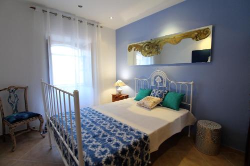 阿尔布费拉Casa Rocha的一间蓝色卧室,配有一张床和镜子