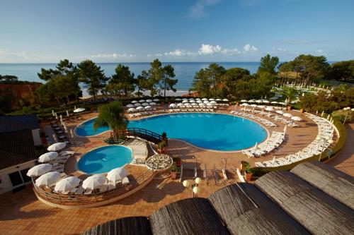 阿尔布费拉法雷西亚波尔图湾酒店的享有带遮阳伞和椅子的游泳池的顶部景致