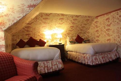剑桥A Cambridge House Inn的酒店客房,设有两张床和一张沙发