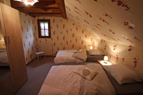 沃洛格河畔格朗热莱斯占姆奥克斯住宿加早餐旅馆的带三张床的客房和鲜花的墙壁