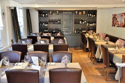 泰格维伦菊克精品酒店的一间带桌椅和葡萄酒瓶的餐厅