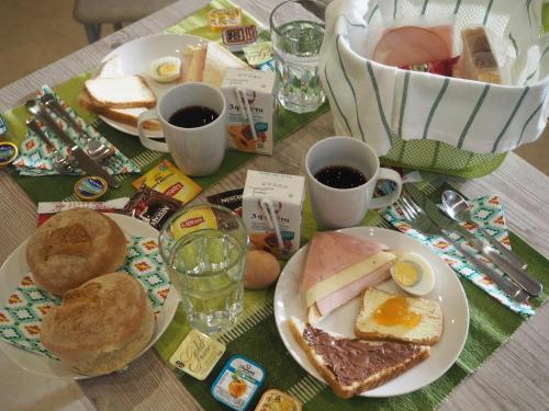 尼亚普拉加Zonita Guest House的餐桌,带早餐盘和咖啡杯