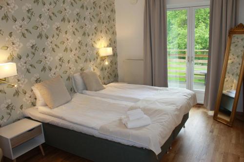 蒙克达尔哼北卡赫加尔德旅馆的一间卧室配有一张带白色床单和镜子的床