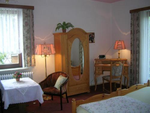 巴特萨克萨萨塔兹膳食公寓酒店的一间卧室配有梳妆台、桌子和镜子