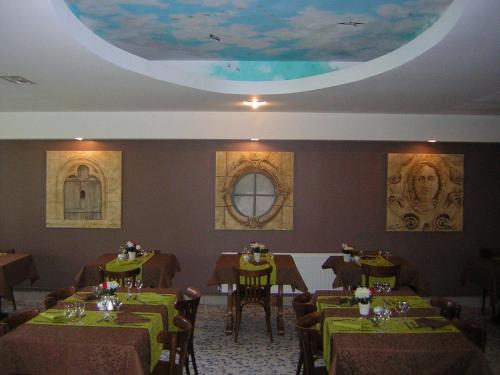 巴勒迪克贝尔特兰德酒店的一间设有绿色桌椅和天花板的用餐室