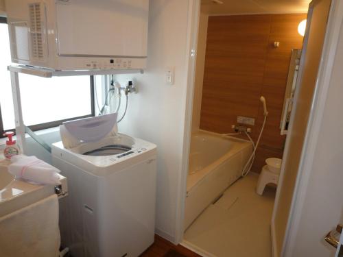 北谷町米哈美克公寓式酒店的浴室配有卫生间、盥洗盆和浴缸。
