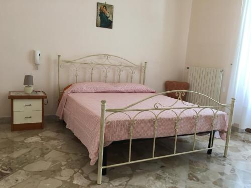 马蒂诺Casa nel Salento da Grace的一间卧室配有一张带粉色毯子的金属床