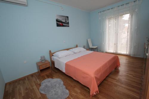 斯普利特Apartman Seaside Paradise的一间卧室配有一张带橙色毯子和窗户的床。