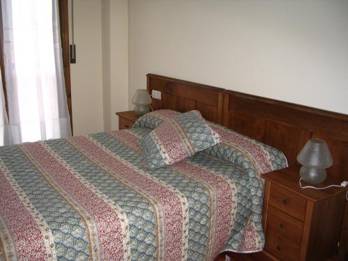 埃切贝里亚Pension Txomin Ostatua的一间卧室配有一张带被子和两盏灯的床。