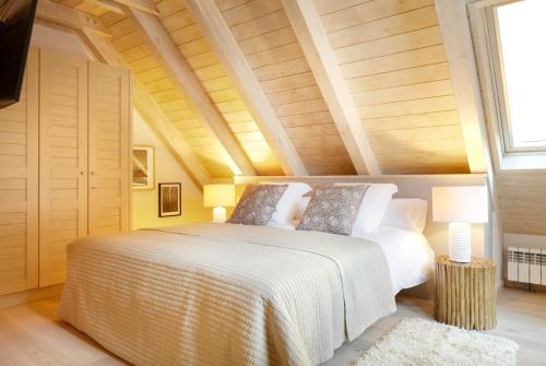 巴奎伊拉-贝莱特Val de Ruda Luxe 50 by FeelFree Rentals的卧室配有白色床和木制天花板
