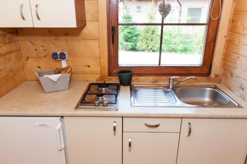 波别罗沃Adria Domki的厨房配有水槽、炉灶和窗户。