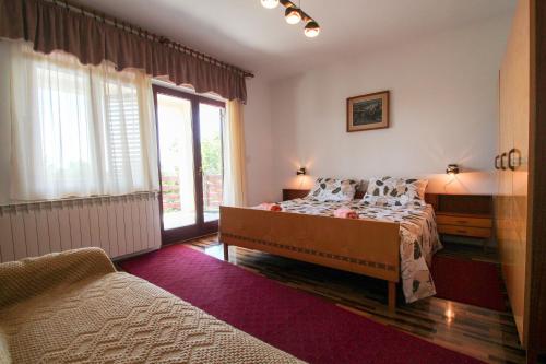 诺维格勒伊斯特拉Zelena oaza Apartment的一间卧室设有一张床和一个大窗户