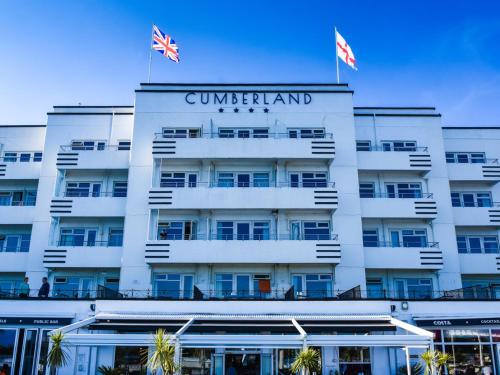 伯恩茅斯坎伯兰海洋休闲酒店的上面有两面旗帜的建筑