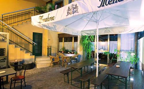 克卢索内德拉波斯塔民宿的一间带桌椅和遮阳伞的餐厅