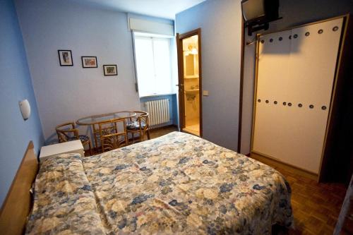 克卢索内德拉波斯塔民宿的一间卧室配有一张床、一张桌子和一个窗户。
