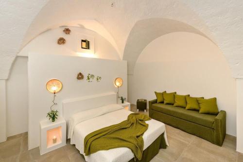 蒙塔尔巴诺Masseria Narducci的一间卧室配有一张床和一张绿色沙发