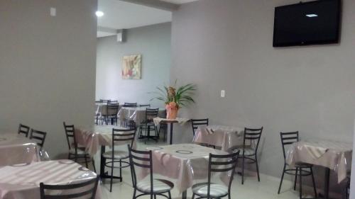 DescansoHotel Descanso的用餐室配有白色桌椅和平面电视
