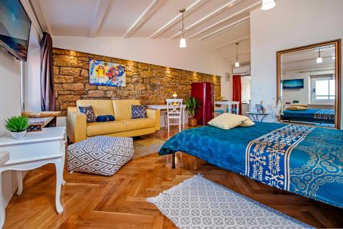 罗维尼Luxury Studio '936'的一间卧室设有一张床和石墙