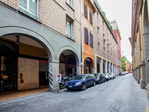 博洛尼亚Appartamenti Astoria的一条城市街道,汽车停在大楼旁边