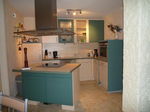 普鲁滕Zum alten Seemann的一个带绿色橱柜和蓝色岛屿的厨房