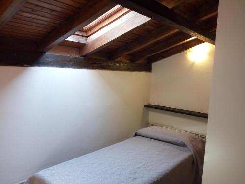 热那亚Villino "Il Rustichetto"的一间带一张床的卧室,位于带木制天花板的房间内