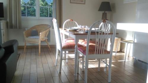 朗迪夫利耶Chambre d'Hotes Les Hortensias的一间带桌子和两把椅子的用餐室
