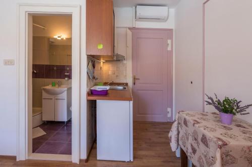 科米扎Apartment Riva 5的厨房配有柜台、水槽和桌子