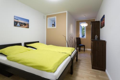 柏林Berlin City Apartments的一间卧室配有一张带黄色床单的大床