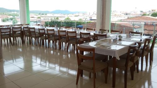 Currais Novos鲍萨达曼克斯酒店的一间带桌椅的用餐室和大窗户