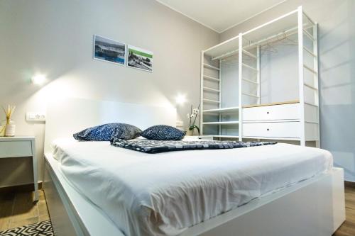 奥帕提亚Apartments Lanča的卧室配有带蓝色枕头的大型白色床