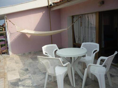 洛泽内茨Hotel Strajica的庭院设有桌椅和吊床。