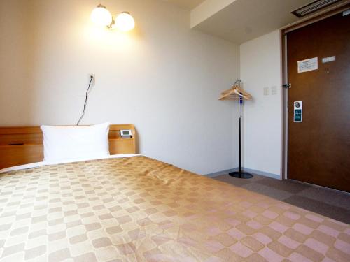 岩国市特伦德岩国酒店的一间卧室配有床、门和灯