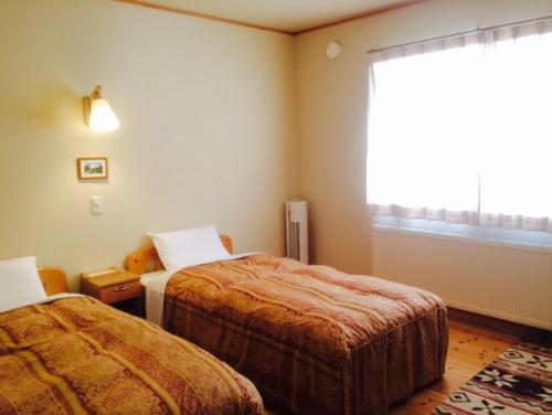 弟子屈町斯帕鲁弟子屈町酒店的酒店客房设有两张床和窗户。