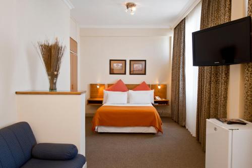 温特和克Hotel Thuringerhof的配有一张床和一台平面电视的酒店客房