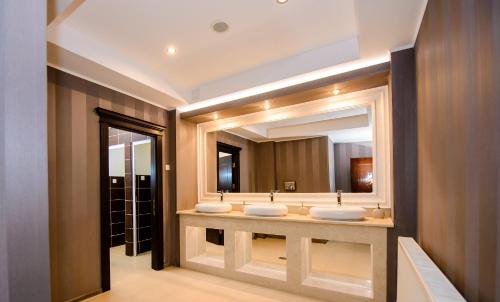 拉姆尼库沃尔恰索菲亚努大酒店的一间带三个水槽和大镜子的浴室