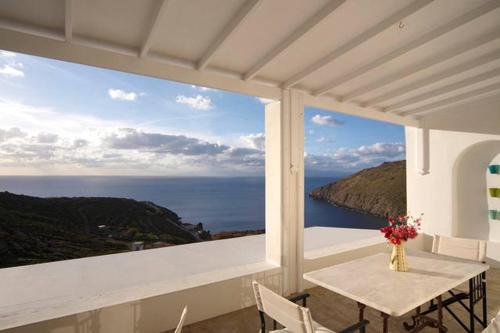 斯科拉Patmos Exclusive Villas的阳台配有桌子,享有海景。