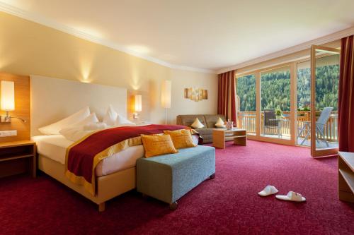 巴德小基希海姆Wohlfühl & Genusshotel Felsenhof的酒店客房设有一张床和一个阳台。
