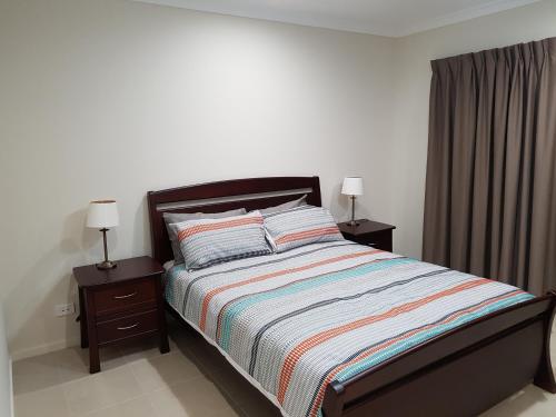 布里斯班贾斯珀广场度假屋的一间卧室配有一张带2个床头柜和2盏灯的床。