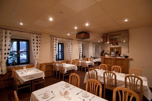 Jevíčko乌帕斯特拉酒店的用餐室配有桌椅和白色的桌布