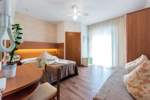 里米尼Hotel Seven的酒店客房配有一张床铺和一张桌子。