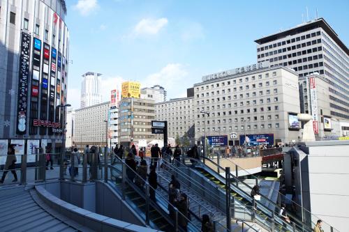 大阪大阪新阪急酒店的一群人沿着城市的街道走着