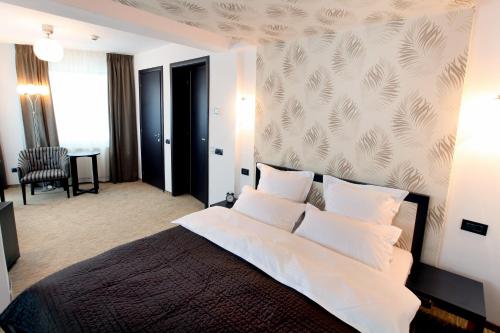 布加勒斯特安比恩斯酒店的卧室配有带白色枕头的大床
