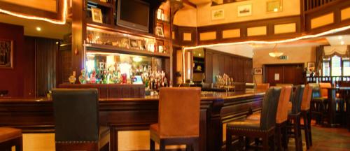 RathowenFeerick's Hotel的餐厅内的酒吧配有椅子和柜台