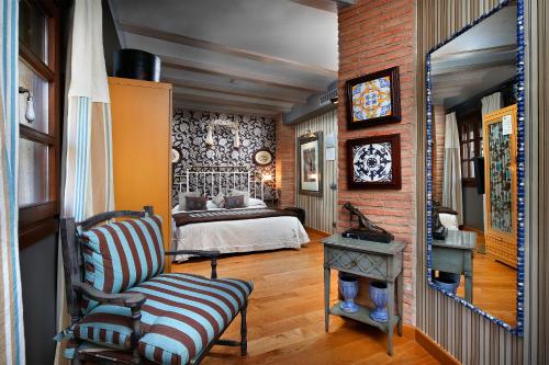 阿尔克萨尔Hotel Boutique Maribel (Adult Only)的一间卧室,卧室内配有一张床和一把椅子