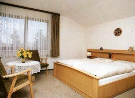 马兰迪钮可尼福酒店的一间卧室配有一张床、一张桌子和一个窗户。