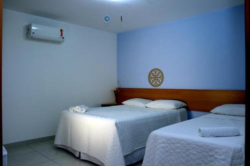 Santa CruzPousada Solar das Conchas的蓝色墙壁客房的两张床