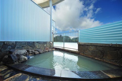 高崎榛名湖温泉日式旅馆的水池,有围栏和建筑