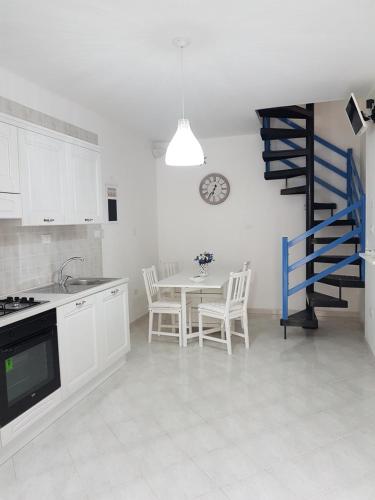 莫诺波利Casa Vacanza La Conchiglia的厨房配有桌子和蓝色螺旋楼梯。