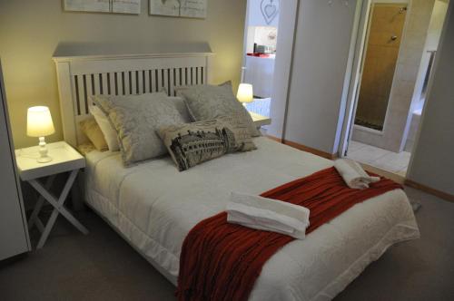 塞吉菲尔德Sedgefield Island Villa的一间卧室配有一张带枕头和桌子的床
